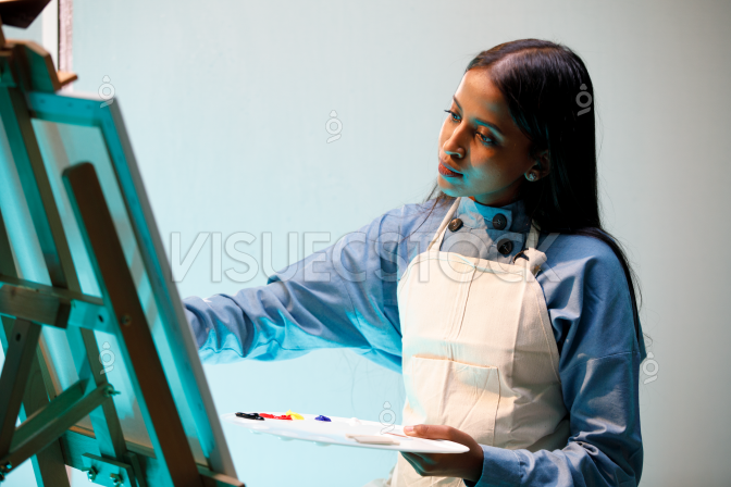  شابة عربيه سعودية مندمجة في الرسم في مرسمها  