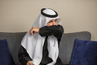 رجل عربي سعودي يغطي العطاس او السعال بكوعه