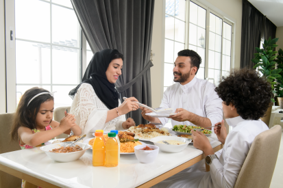 عائل سعودية تستمتع بوقتها معًا أثناء امحادثة وناول الداء في المنزل