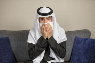 رجل عربي سعودي يسعل في منديل